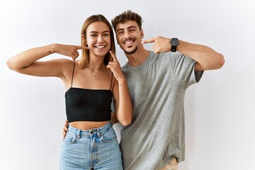 Young beautiful couple standing together over isolated background smiling cheerful showing and...
