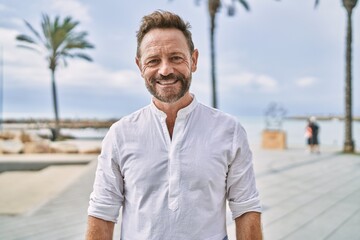 Middle age man smiling confident by the sea