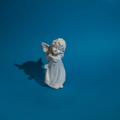 Little angel  of love in white color on a blue background