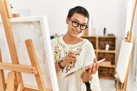 Young hispanic woman smiling confident drawing at art studio
