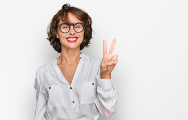 Young hispanic woman wearing business style and glasses showing and pointing up with fingers number...
