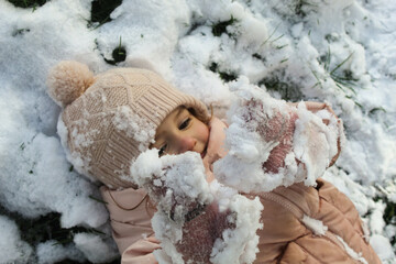 the child lies in the snow. Winter. Cheerful childhood. happy child. Snowdrifts. Winter's tale