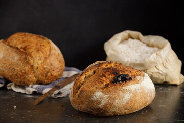 Rustic sourdough bread with tomato on a black marble table.