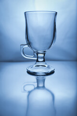 Still life with empty glass latte cup and it's reflection