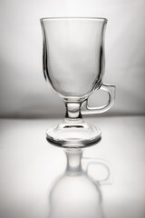 Still life with empty glass latte cup and it's reflection