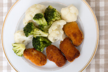 Dinner on a white plate that is on a dark background