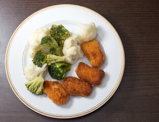 Dinner on a white plate that is on a dark background