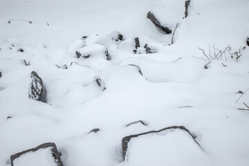 Grey boulders partially buried in snow