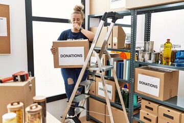 Young caucasian woman volunteer holding donations box feeling unwell and coughing as symptom for cold or bronchitis. health care concept.