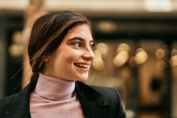 Young beautiful businesswoman smiling happy standing at the city.