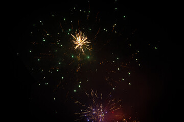 Fajerwerki w nowy rok, kolorowe sztuczne ognie, barwne rozbłyski światła na tle nocnego nieba.