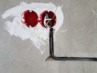 Electrical wires with cables at home repair. New electrical sockets on concrete wall