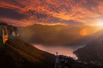 Silhouette of an adventurous person contemplating an impressive landscape. Fantastic landscape on...