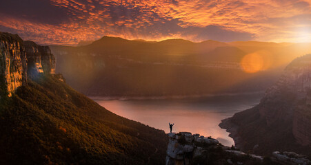 Silhouette of an adventurous person contemplating an impressive landscape at sunset. Morro de...