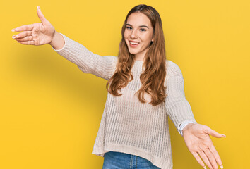 Young blonde woman wearing casual clothes looking at the camera smiling with open arms for hug. cheerful expression embracing happiness.