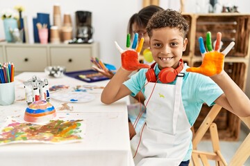Brother and sister wearing headphones showing painted palm hands at art studio