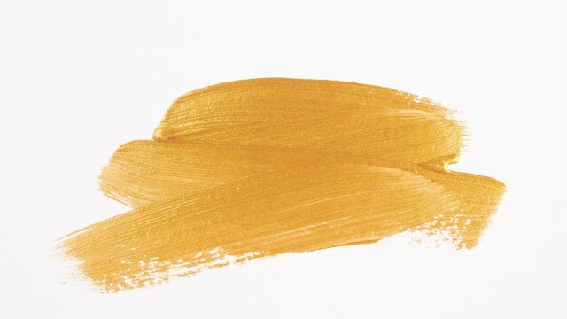 Abstract brushstrokes of gold paint brush applied isolated on a white background. Gold paint smear texture. Golden sparkling textured artistic illustration. Smears of cosmetics. High quality 4k 
