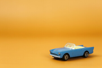 Kinder surprise toys on an orange background. Happy childhood. Toys. Kinder egg. Small car models. Toy cars.