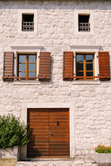 Fototapeta na wymiar Facade of an old shuttered stone house in Perast. Montenegro