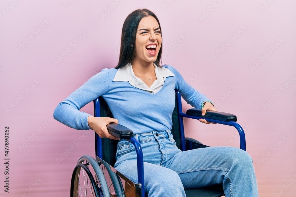 Canvas Prints Beautiful woman with blue eyes sitting on wheelchair angry and mad screaming frustrated and furious, shouting with anger. rage and aggressive concept.