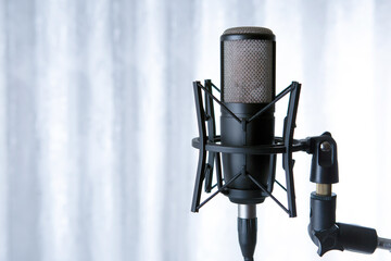 studio black condenser microphone against gray curtains