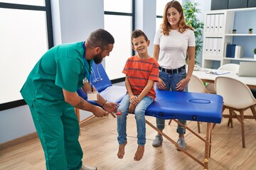 Family having medical consultation doing reflex knee test at clinic