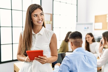 Group of business workers working sitting on the table. Woman smiling happy and using touchpad standing at the office.