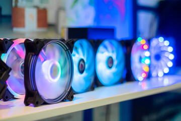 Many colorful pc coolers, cooling fans with neon LED light on table at computer exhibition, trade...