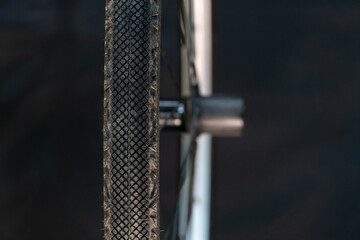 Bicycle wheel close-up on a black background. New silver rim and tire of a mountain bike. Studio background, selective focus.
