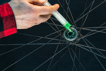 Bicycle hub and wheel close-up on a black background. Bushing bulkhead, replacement of lubrication and bearings. Mountain bike repair.