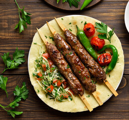 Fototapeta Turkish Adana Kebab with fresh vegetables on flatbread obraz
