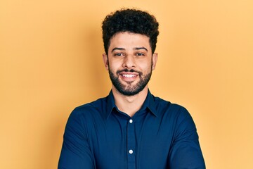Young arab man with beard wearing casual shirt happy face smiling with crossed arms looking at the...
