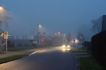 Auto im Nebel. Nebel, Straße, neblig Strasse im Nebel. Scheinwerfer. Straßenlaternen, Licht im Nebel, blaue Stunde