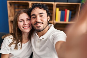 Fototapeta premium Man and woman hugging each other make selfie by the smartphone at home
