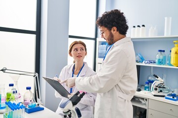 Fototapeta premium Man and woman scientist partners working at laboratory