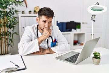 Fototapeta premium Young doctor working at the clinic using computer laptop feeling unwell and coughing as symptom for cold or bronchitis. health care concept.