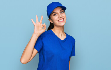 Young hispanic girl wearing delivery courier uniform smiling positive doing ok sign with hand and fingers. successful expression.