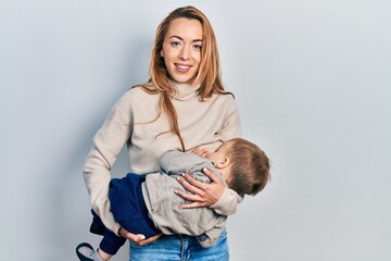 Young caucasian woman holding and hugging her son breastfeeding him, maternity lactation