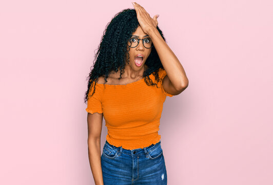 Middle age african american woman wearing casual clothes and glasses surprised with hand on head for mistake, remember error. forgot, bad memory concept.
