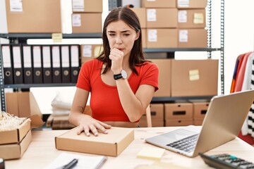 Young hispanic woman preparing order working at storehouse feeling unwell and coughing as symptom for cold or bronchitis. health care concept.