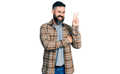 Hispanic man with beard wearing casual shirt smiling with happy face winking at the camera doing...
