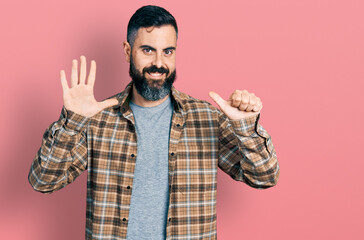 Hispanic man with beard wearing casual shirt showing and pointing up with fingers number six while smiling confident and happy.