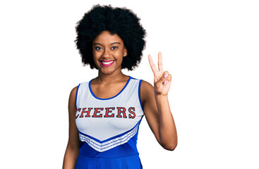 Young african american woman wearing cheerleader uniform showing and pointing up with fingers...