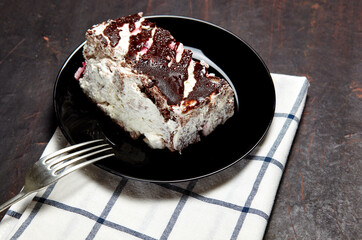 Plate with slice of tasty chocolate cake on table. Yummy dessert on on wooden background, closeup