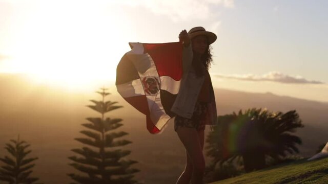 woman with dominican flag at sunset