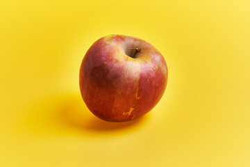  Single red apple fruit over yellow background