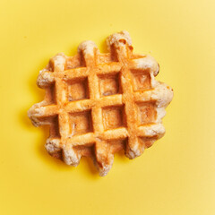  Single delicious waffle over yellow background