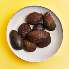  Bowl of avocados fruit over yellow background