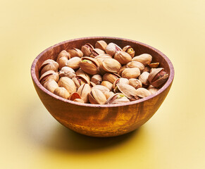  Bowl of pistachios over yellow background
