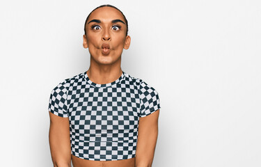 Hispanic transgender man wearing make up and long hair wearing modern clothes making fish face with lips, crazy and comical gesture. funny expression.